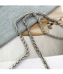 Détail de la bandoulière en chaîne métallique tressée argentée pour sac seau chic