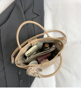 Top view of beige lychee pattern bucket bag showing spacious interior and silk scarf detail