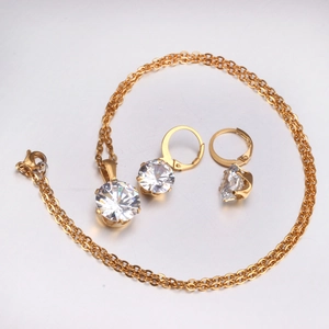 Detail of elegant gold-toned jewelry set with six-prong round cut sparkling gemstones