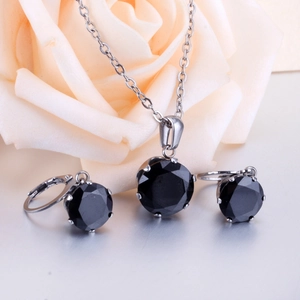 Close-up of elegant six-prong black gemstone jewelry set with necklace and stud earrings