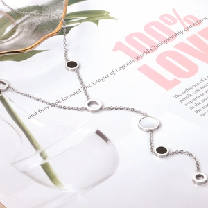 Detail of silver chain necklace with circular shell pendants on a lifestyle background