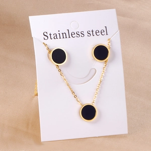 Detail of gold stainless steel necklace and stud earrings set with black round shell inlay