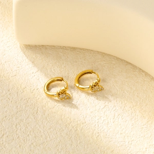 Détail macro de boucles d'oreilles papillon dorées avec incrustation de zircone