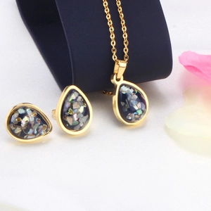 Detail of gold water drop jewelry set with colorful opal inlay on white fabric