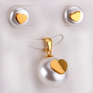 Dettaglio del set di gioielli con perle bianche e motivo a cuore dorato e orecchini