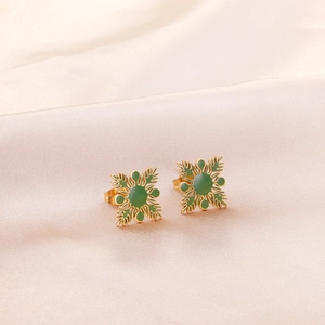 Boucles d'oreilles en acier doré et émail vert sur un fond délicat en soie rose