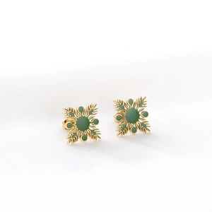 Vue détaillée de boucles d'oreilles fleurs dorées avec émail vert de style rétro
