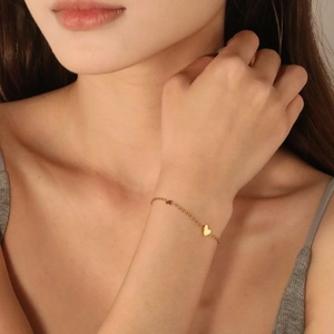 Minimalist gold stainless steel hollow oval bracelet with heart pendants on model wrist