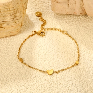 Close-up of golden stainless steel heart bracelet with lobster clasp and extension chain
