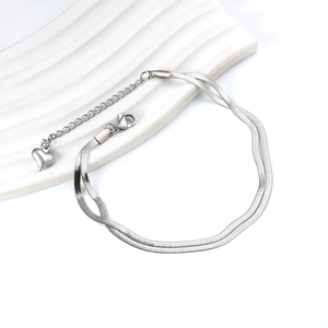 Silver double layer snake chain anklet with heart pendant and lobster clasp on ceramic