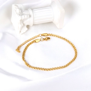 Detail of gold double layer snake chain anklet with lobster clasp and heart pendant