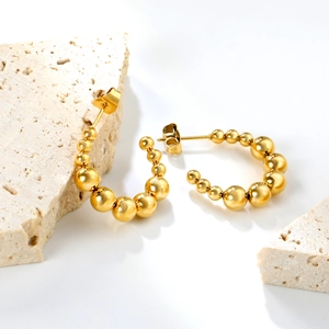 Detail of 18K gold plated stainless steel C-shaped earrings with gradient bead design