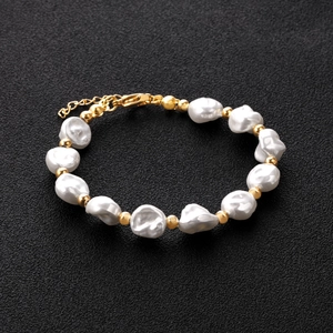 Macro detail of baroque pearls with golden steel beads and adjustable lobster clasp
