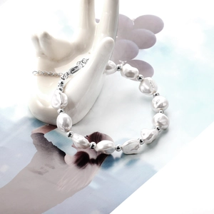 Baroque pearl bracelet with silver steel beads displayed on a white hand model