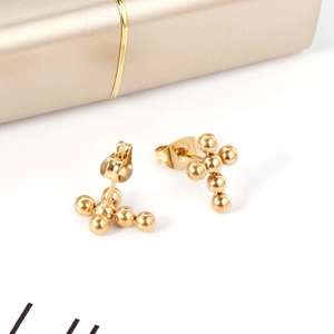Gros plan de boucles d'oreilles croix en acier inoxydable plaqué or avec perles