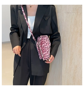 Pink leopard print coffin bag with silver rivets shown worn across the body