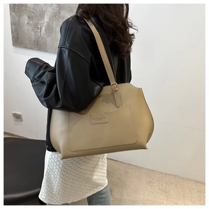 Grand sac cabas beige porté par un mannequin pour montrer son style et sa capacité