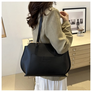 Détail d'un cabas noir minimaliste avec bandoulière et poche extérieure élégante