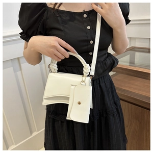 Détail du sac sablier blanc avec poignée tressée et pendentif porte-monnaie amovible