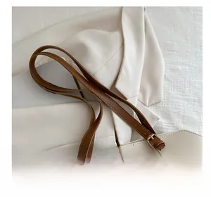 Détail de la bandoulière réglable avec boucle dorée sur un sac cabas beige et marron