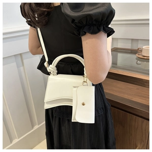 Vue détaillée du sac à main blanc en similicuir avec poignée nouée et mini pochette assortie