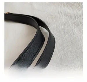 Detail shot of reinforced double stitching and smooth finished edges on black leather tote handles
