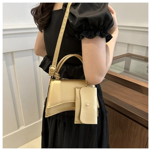 Vue détaillée du sac à main doré avec base asymétrique et pochette assortie