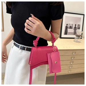 Détail du sac à main fuchsia en sablier avec poignée nouée et mini pochette assortie