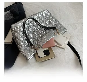 Silver quilted tote bag showing large capacity for tablet, phone, and wallet