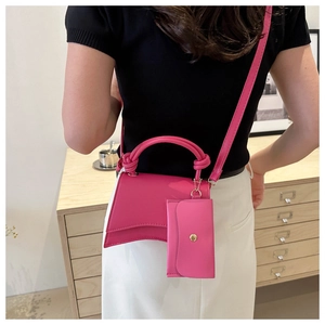 Sac à main sablier rose fuchsia avec mini pochette et poignée à nœud porté par mannequin