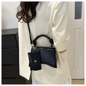 Détail du sac à main sablier noir avec base incurvée unique et poignée nouée décorative