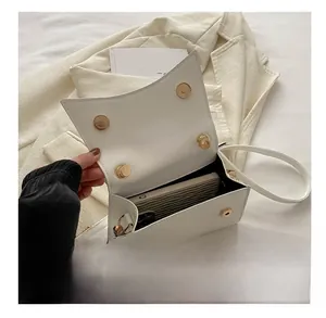 Vue de dessus du sac bandoulière ouvert en cuir blanc montrant l'espace intérieur