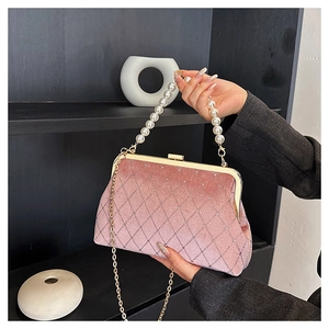 Close-up of pink velvet evening bag with rhinestone quilting and pearl top handle