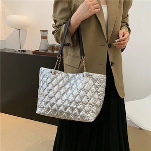 Silver quilted tote bag with metallic finish and gold chain straps for daily commute