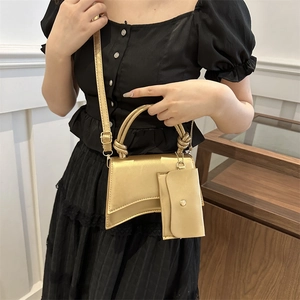 Sac à main doré métallisé avec base incurvée et mini porte-monnaie assorti en bandoulière