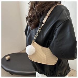 Dettaglio borsa a mezzaluna beige in ecopelle trapuntata con catena in metallo oro