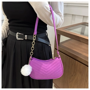 Dettaglio della borsa hobo in feltro viola con trapuntatura a V e pompon bianco