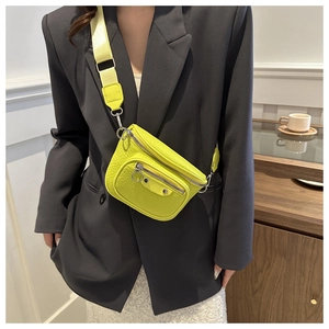 Detail of neon yellow waist bag with faux crocodile texture and metal rivets