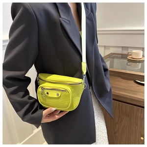 Detail of lemon yellow croc-effect crossbody bag with silver hardware and wide strap