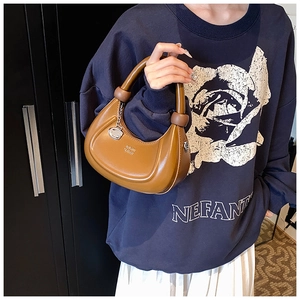 Detail der braunen Vintage-Leder-Mondtasche mit rundem Griff und Markenlogo-Prägung