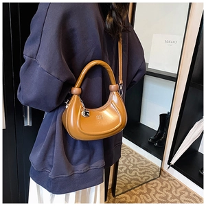 Braune Halbmond-Tasche aus Leder mit GOLD LION Logo am Model getragen für Freizeit