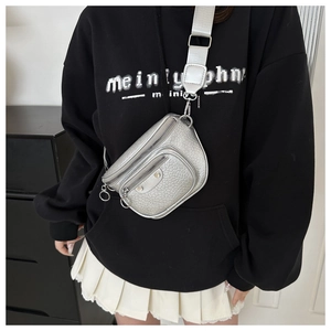 Detail of silver crocodile embossed waist bag with wide strap and metallic zippers