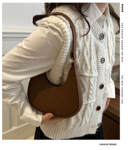 Detailed view of the brown crocodile-embossed faux leather crescent shoulder bag texture