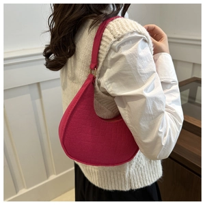 Detail van de roze krokodillentextuur op een trendy halvemaanvormige okseltas voor dames