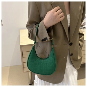 Detail van groene hobo-tas met krokodillenreliëf, gouden gespen en slanke schouderriem