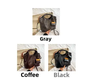 Detailed comparison of grey, coffee, and black leather bucket bags with mini charm pouches