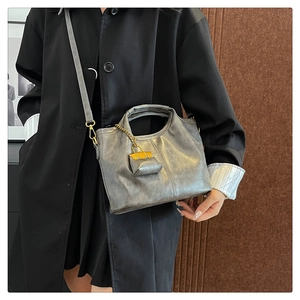 Detail of grey vintage bucket bag with metallic texture and decorative micro pouch