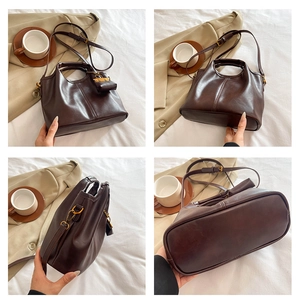Detail view of vintage dark brown leather handbag with shoulder strap and mini pouch