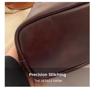 Close-up of precise stitching and premium dark brown leather texture on bucket bag
