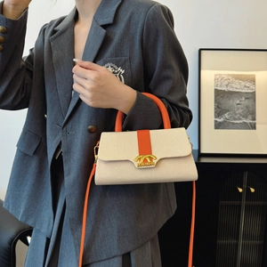 Modische beige Web-Box-Tasche mit orangen Griffen und Goldverschluss zu grauem Anzug